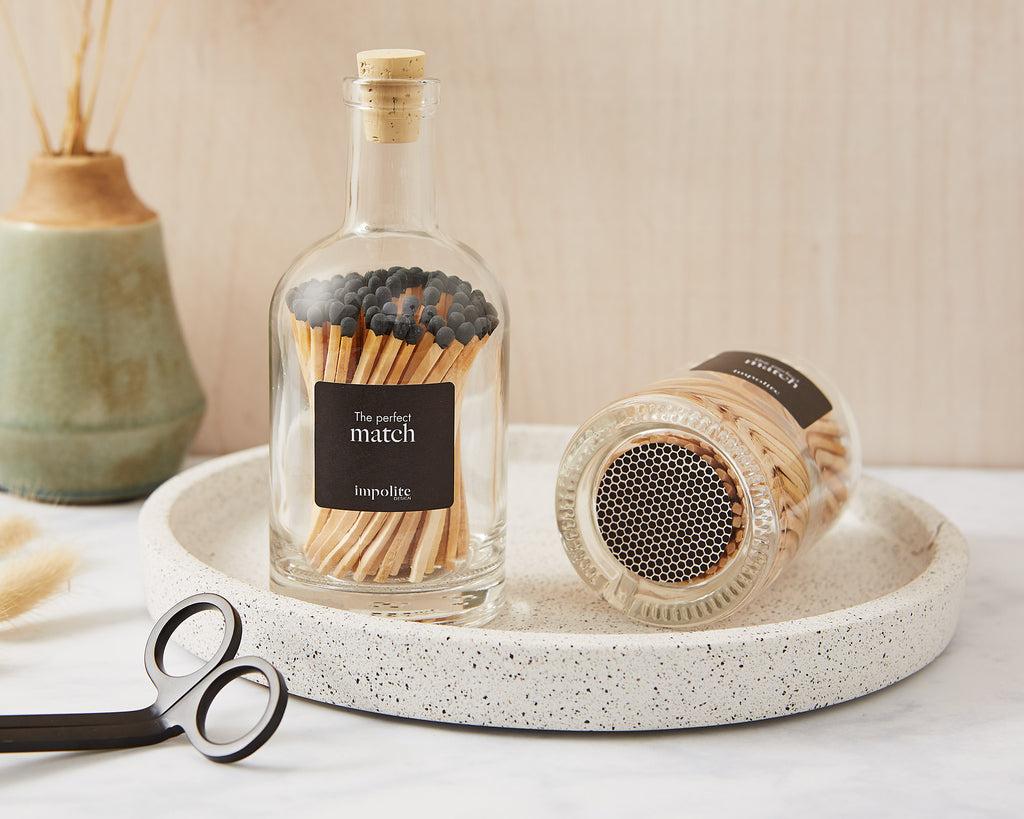 Stylish glass bottle of coloured matches with strike pad on the bottom for candles