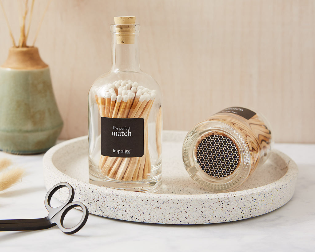Stylish glass bottle of coloured matches with strike pad on the bottom for candles