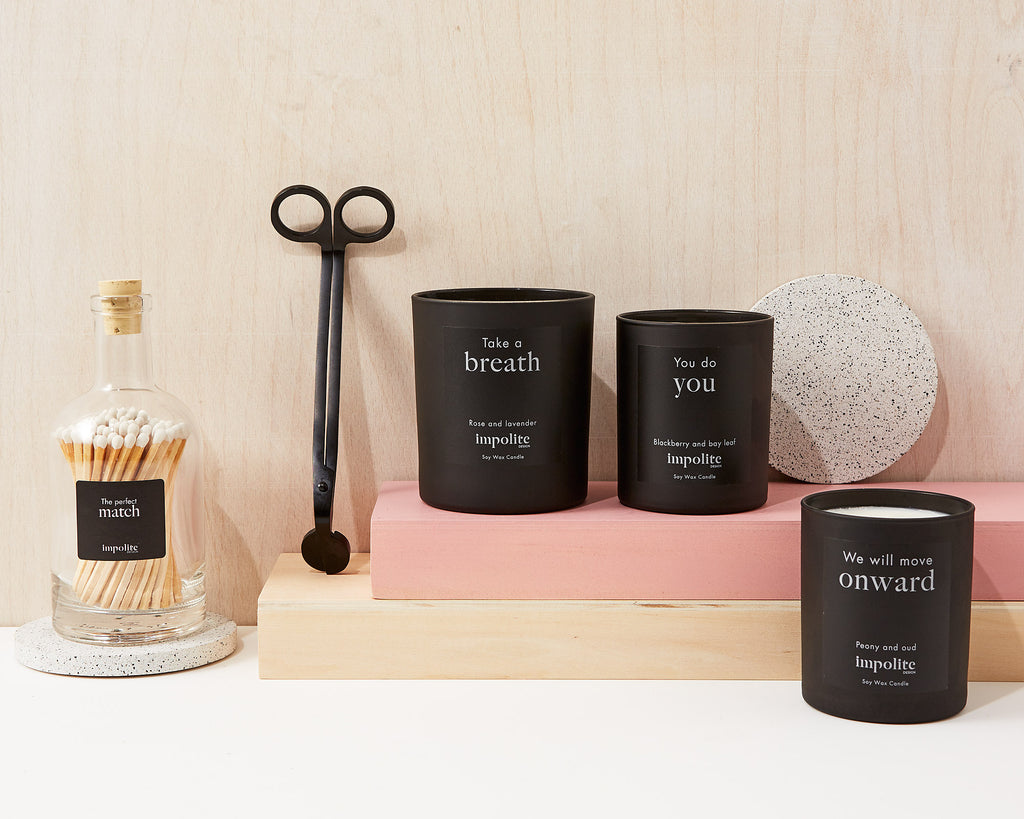 Selection of Impolite Design candles, wick trimmer accessories and glass bottle of matches